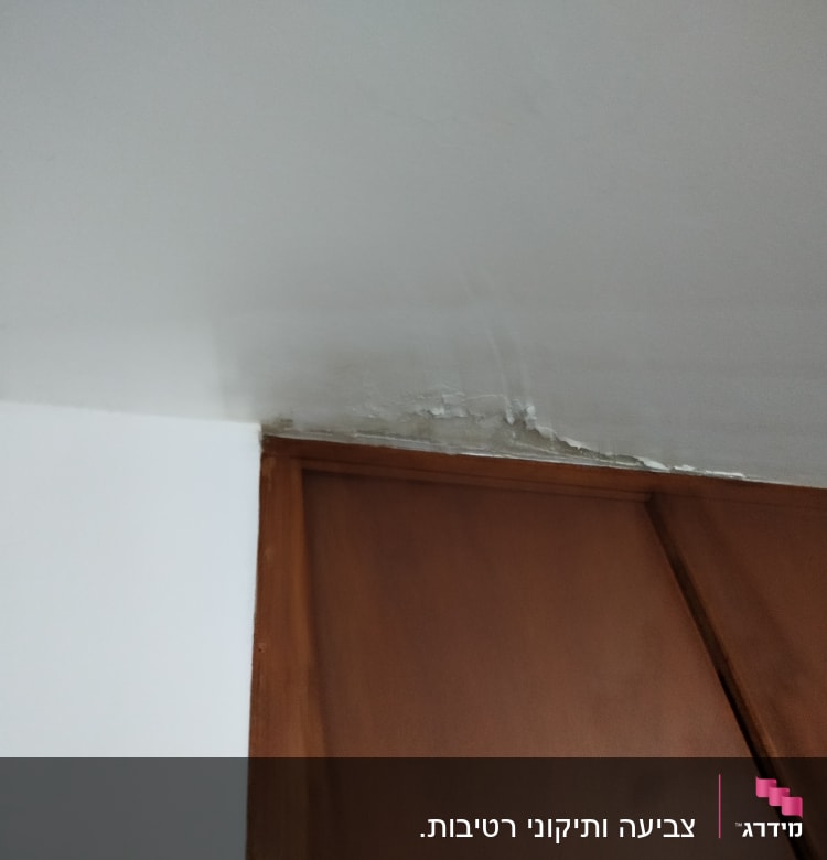 תקרה עם סימני רטיבות מעל ארון עץ